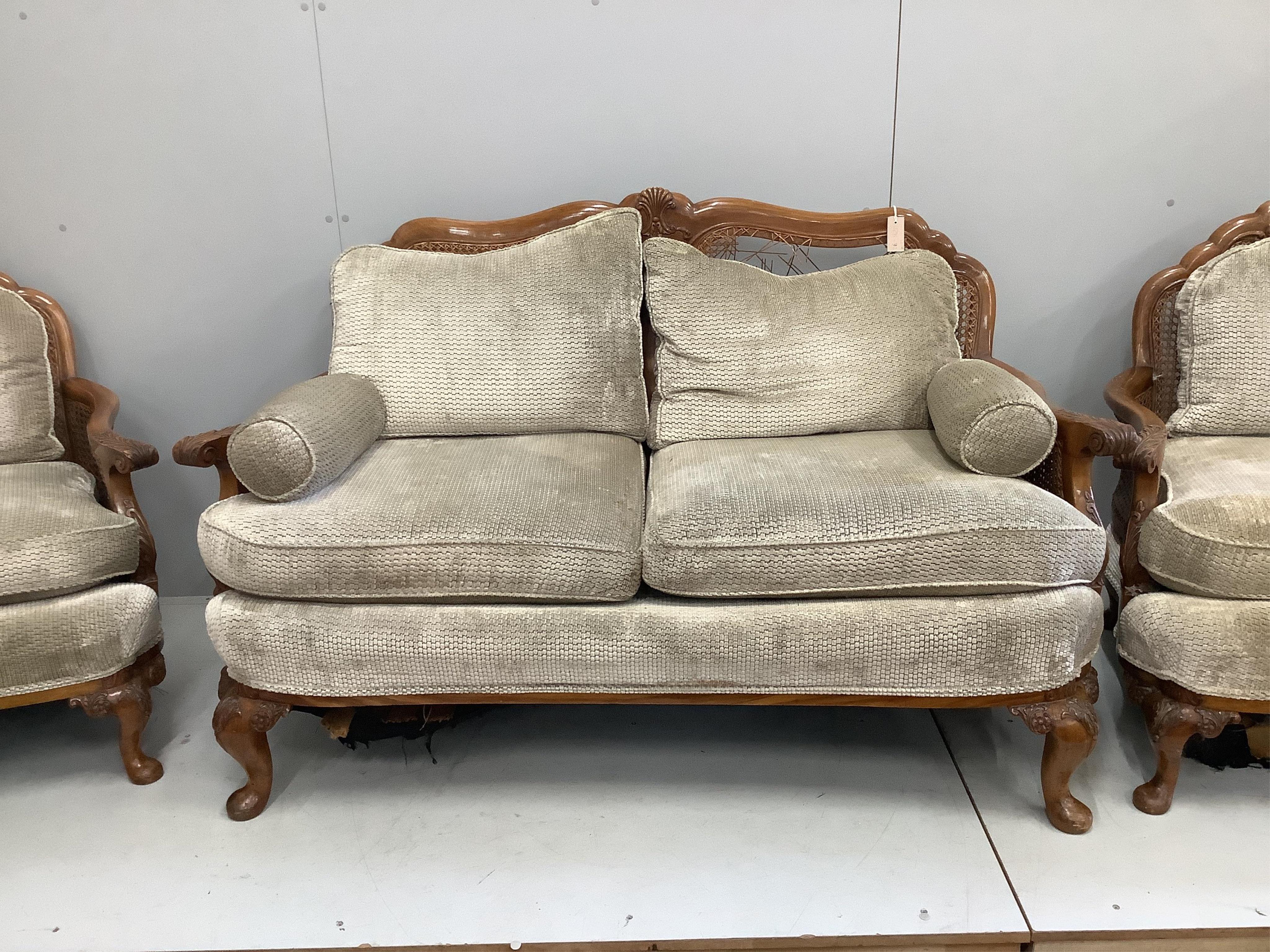 A Queen Anne Revival walnut three piece Bergere suite, cane in need of extensive repair, settee width 156cm, depth 74cm, height 94cm. Condition - poor